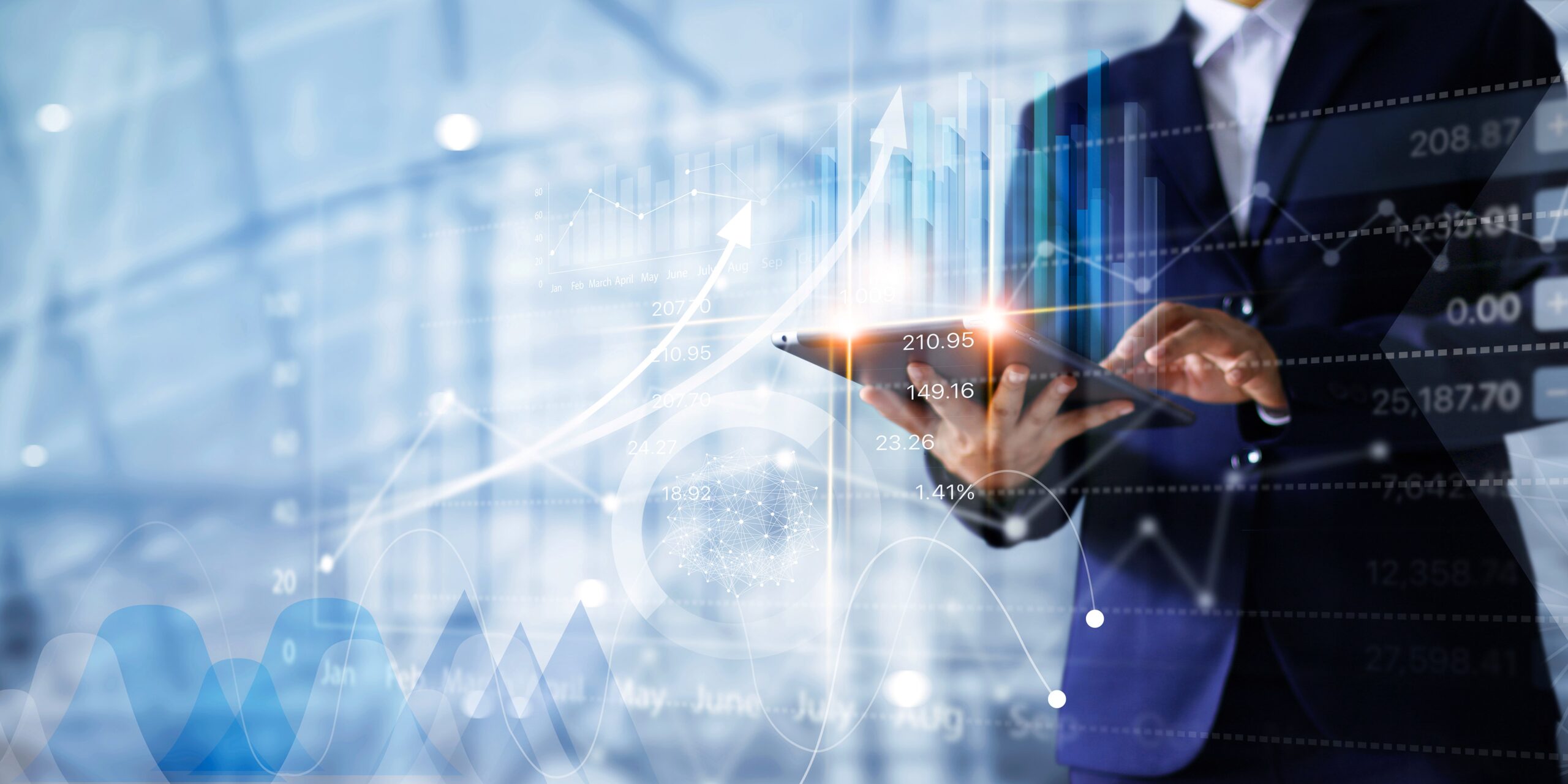eschäftsperson im Anzug bedient ein Tablet, im Hintergrund sind digitale Finanzdiagramme und Wachstumskennzahlen zu sehen.